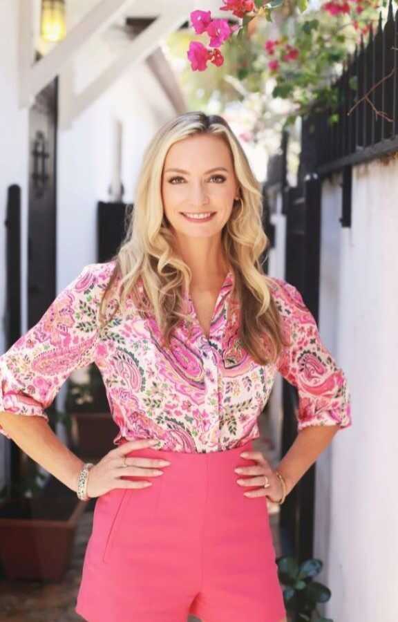 woman stands in courtyard with hands on hips